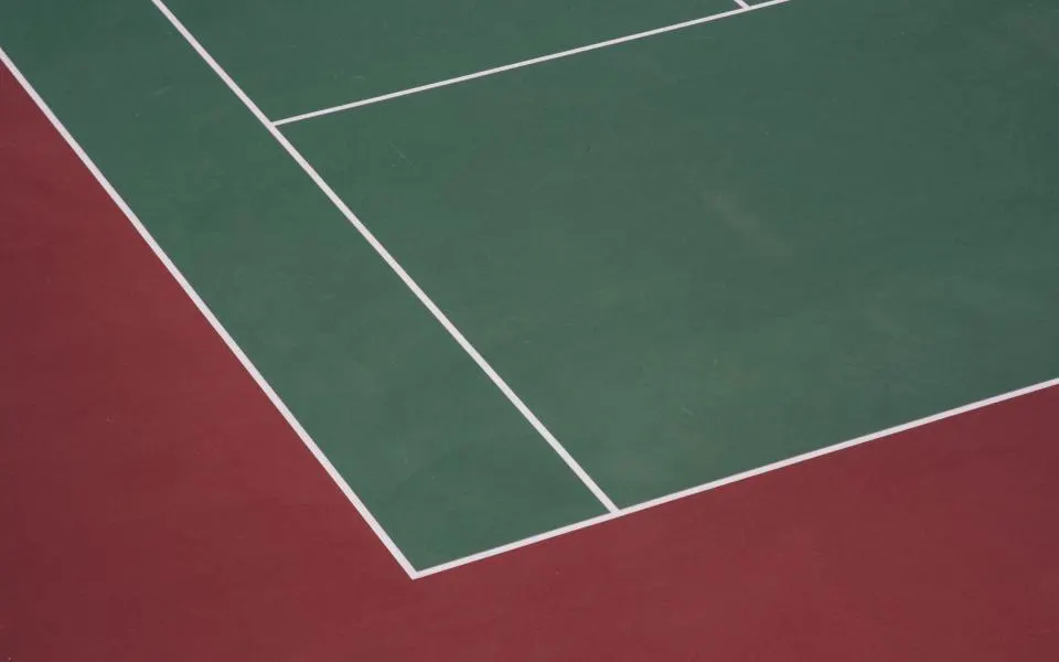 Sunlit tennis court with clear boundary lines